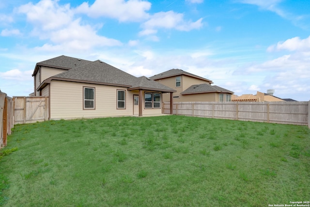 rear view of house featuring a lawn