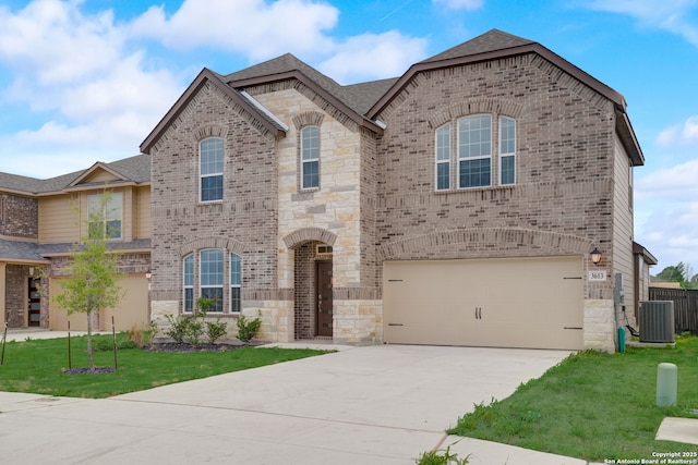 view of front of property featuring a garage, a front lawn, and central air condition unit