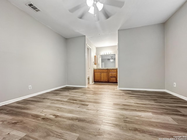 unfurnished bedroom with light wood-type flooring, ensuite bath, visible vents, and baseboards