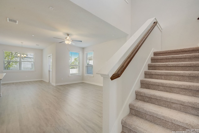 stairway with hardwood / wood-style flooring and ceiling fan