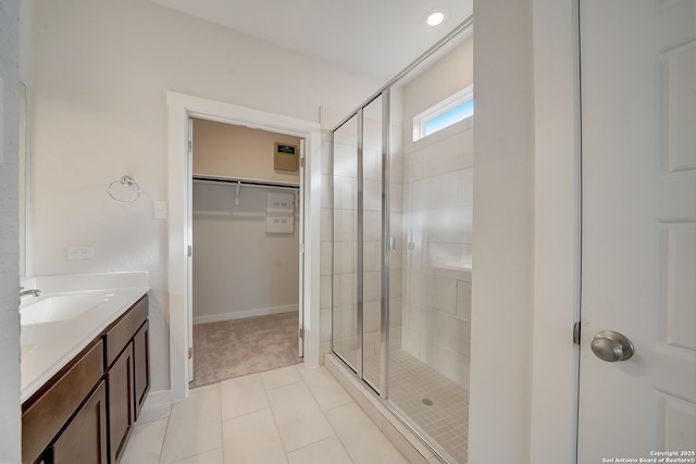 bathroom featuring walk in shower, vanity, and tile patterned flooring