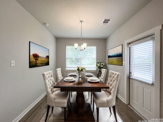 dining area with an inviting chandelier, dark hardwood / wood-style flooring, and a healthy amount of sunlight