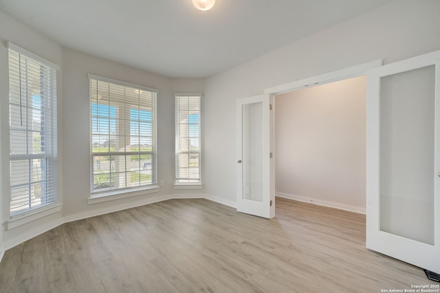 unfurnished bedroom with french doors and light hardwood / wood-style flooring