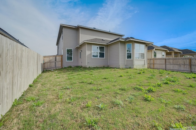 rear view of property featuring a lawn