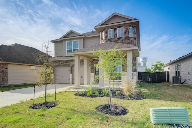 view of front of home with central AC unit, a garage, and a front yard