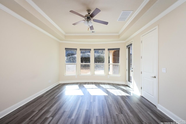 spare room featuring crown molding, ceiling fan, dark hardwood / wood-style floors, and a raised ceiling