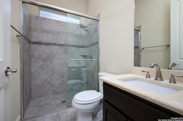 bathroom with vanity, a shower with shower door, tile patterned floors, and toilet