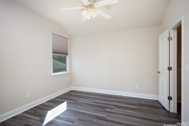 spare room with vaulted ceiling, dark hardwood / wood-style floors, and ceiling fan