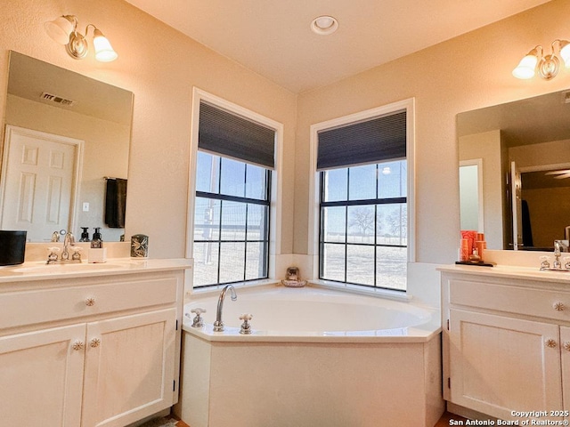 bathroom with a washtub and vanity