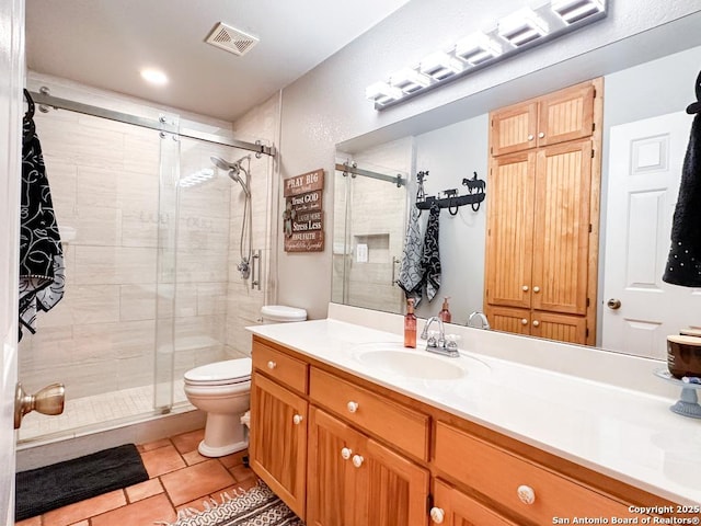 bathroom featuring vanity, a shower with shower door, tile patterned floors, and toilet