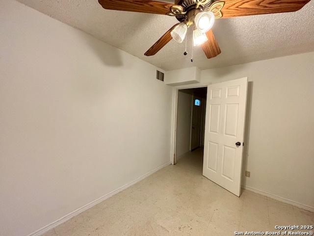 spare room featuring ceiling fan and a textured ceiling