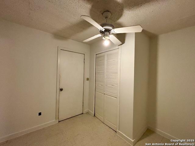 unfurnished bedroom featuring ceiling fan, a closet, and a textured ceiling