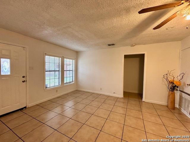 tiled entrance foyer featuring ceiling fan and a textured ceiling