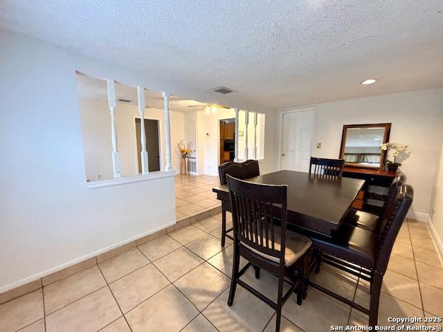 tiled dining room with a textured ceiling