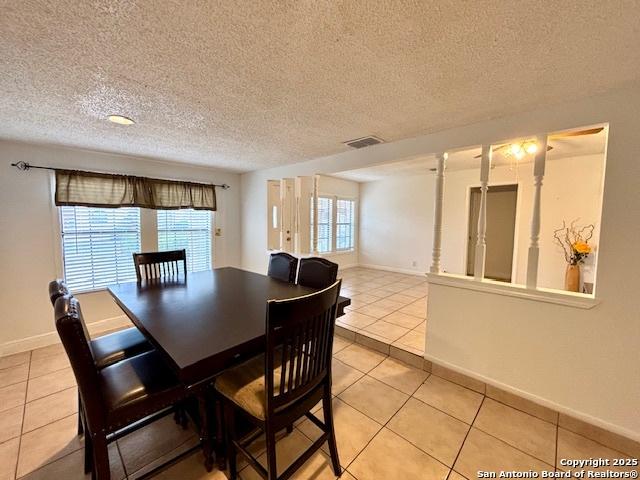 tiled dining area featuring a textured ceiling