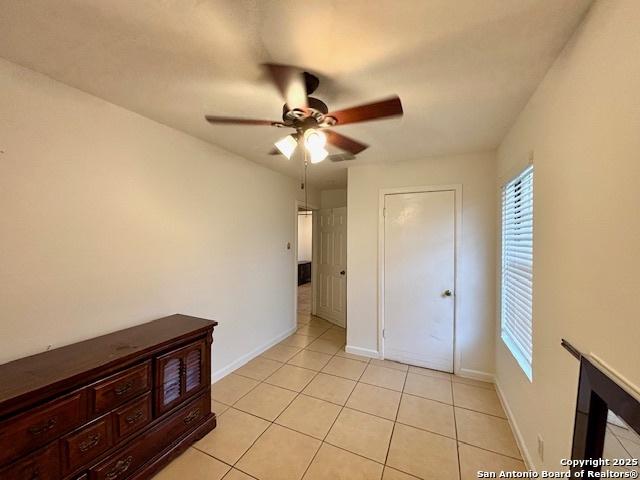 unfurnished bedroom with light tile patterned flooring and ceiling fan