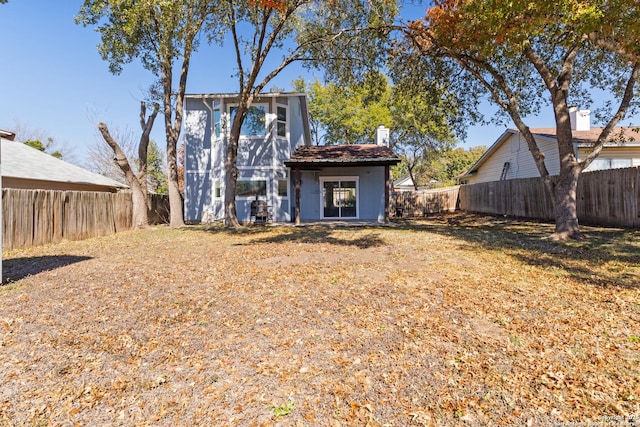 rear view of property with a yard