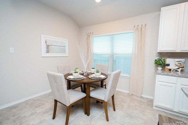 dining space featuring vaulted ceiling and plenty of natural light