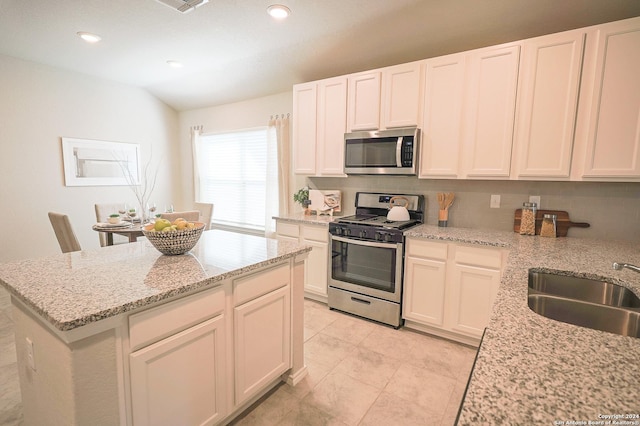 kitchen featuring light stone counters, sink, tasteful backsplash, and stainless steel appliances