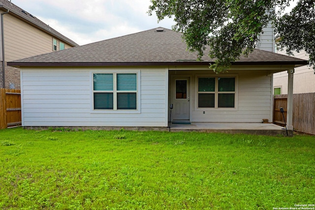 rear view of house featuring a yard and a patio