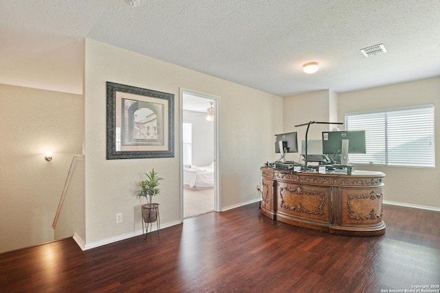 office area with dark hardwood / wood-style floors and a textured ceiling