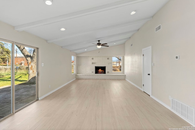 unfurnished living room with vaulted ceiling with beams, a fireplace, light hardwood / wood-style floors, and ceiling fan