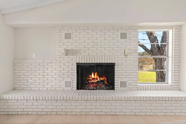 details featuring hardwood / wood-style floors and a brick fireplace