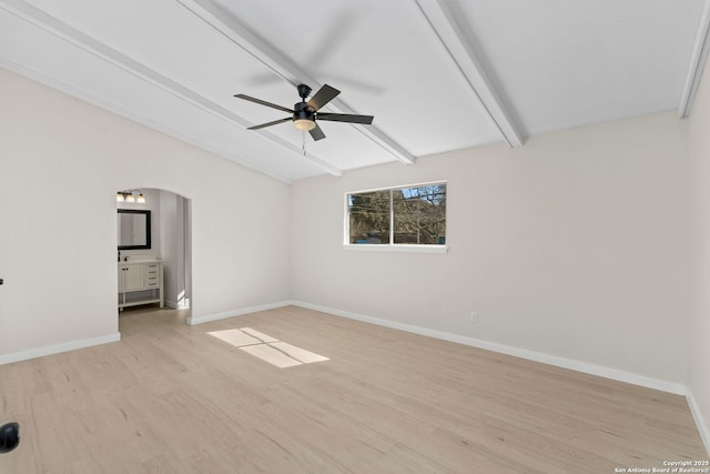 unfurnished bedroom featuring lofted ceiling with beams, ceiling fan, connected bathroom, and light hardwood / wood-style floors