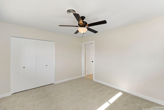 unfurnished bedroom with light carpet, ceiling fan, and a closet