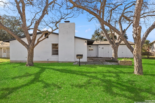 rear view of house with a yard and a patio area