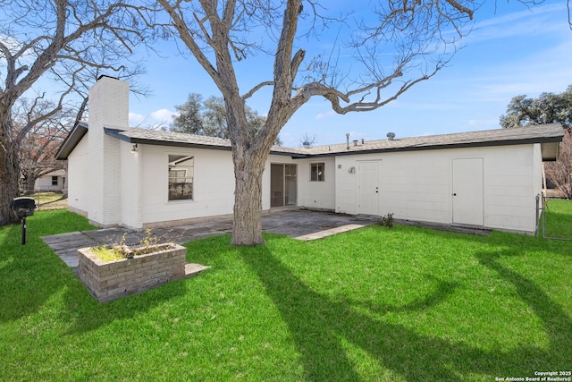 back of house with a patio area and a lawn