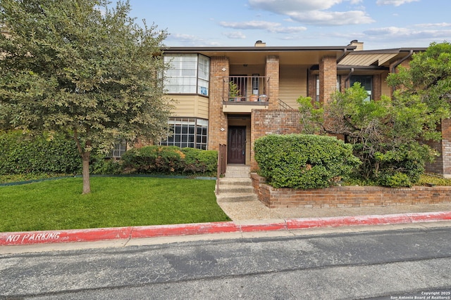 view of front of property with a balcony and a front yard