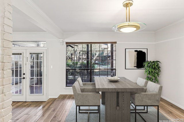 dining space featuring crown molding, hardwood / wood-style floors, and french doors