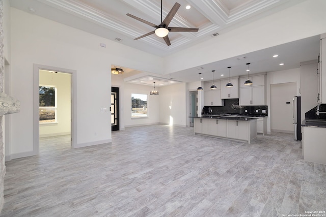 kitchen with white cabinetry, beam ceiling, a center island, coffered ceiling, and decorative light fixtures