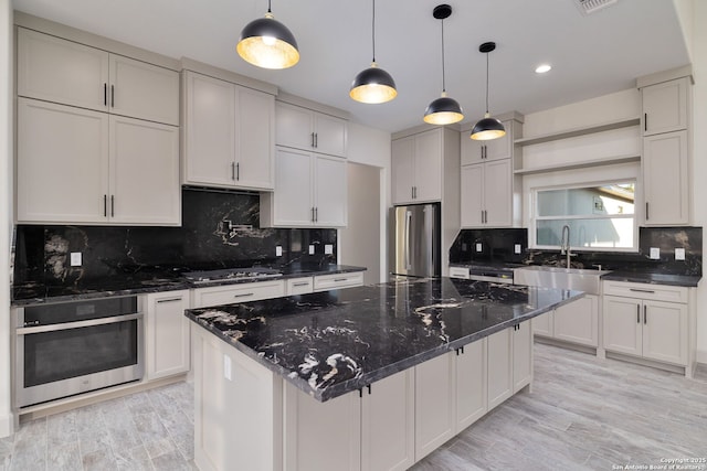 kitchen featuring a kitchen island, decorative light fixtures, white cabinets, dark stone counters, and stainless steel appliances