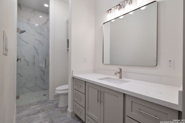 bathroom with vanity, hardwood / wood-style flooring, toilet, and walk in shower