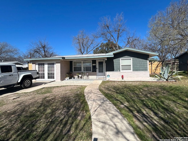 ranch-style house with a porch and a front lawn