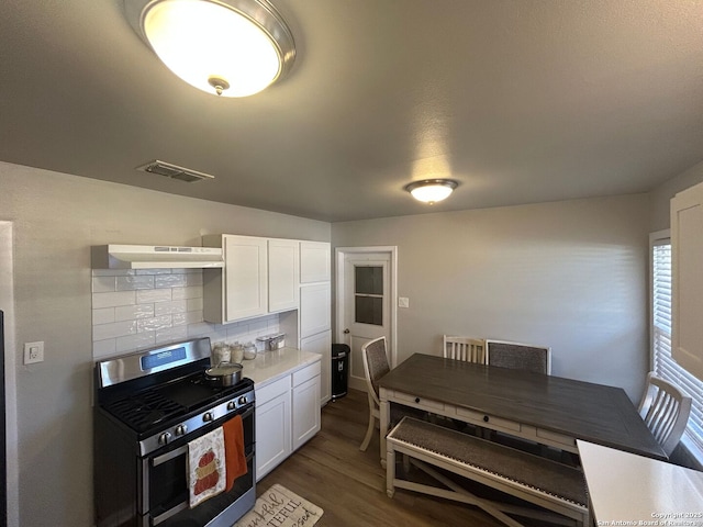 kitchen featuring white cabinetry, stainless steel gas range, dark hardwood / wood-style floors, and tasteful backsplash