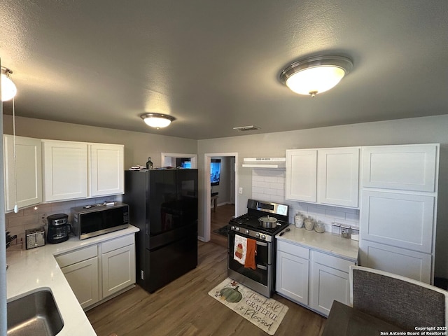 kitchen with dark wood-type flooring, sink, tasteful backsplash, appliances with stainless steel finishes, and white cabinets