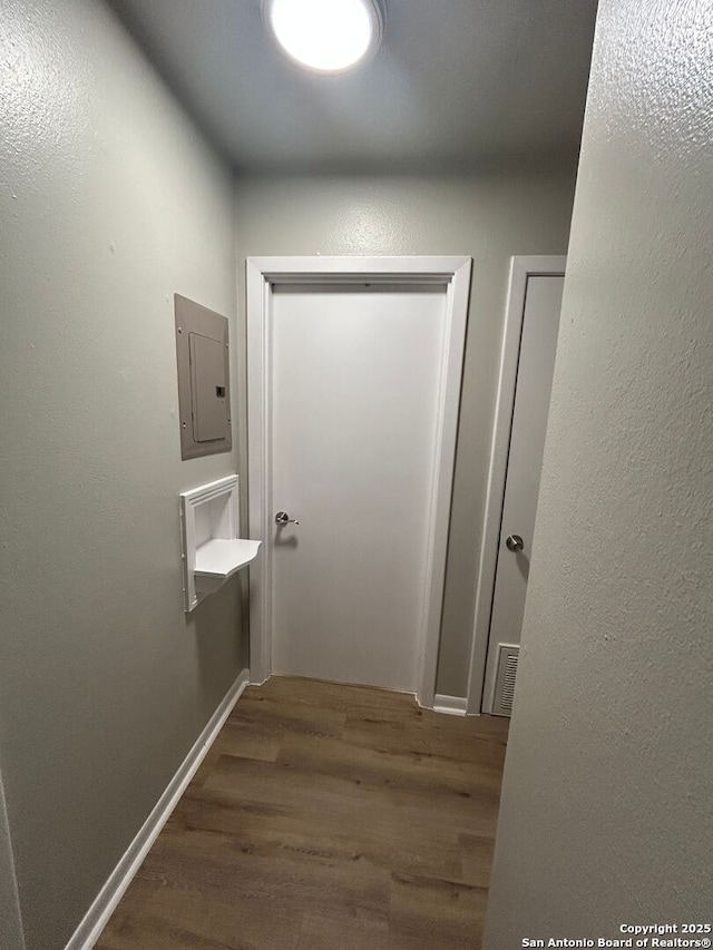 corridor featuring dark wood-type flooring and electric panel