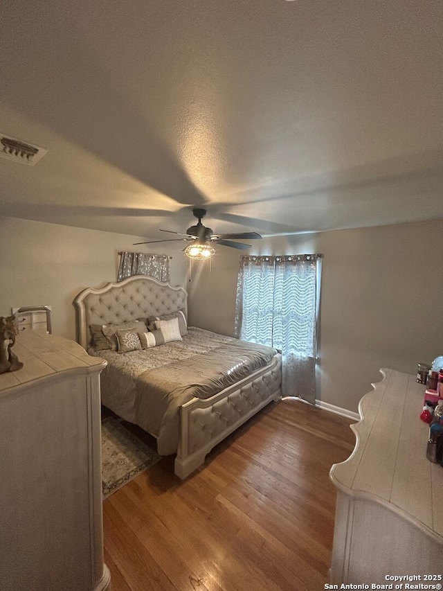 bedroom featuring hardwood / wood-style flooring, a textured ceiling, and ceiling fan