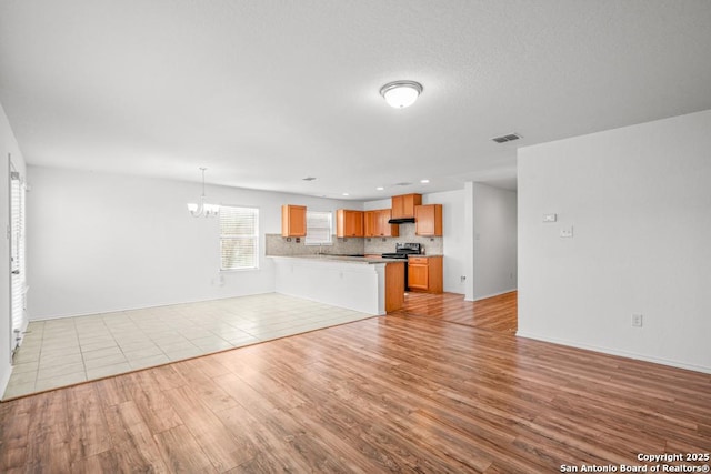 unfurnished living room with light hardwood / wood-style floors and a chandelier