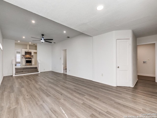 unfurnished living room featuring light wood-type flooring and ceiling fan