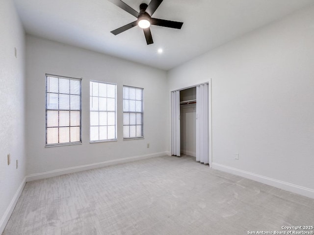 unfurnished bedroom with ceiling fan, a closet, and light carpet