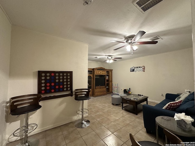 living room featuring light tile patterned floors, a textured ceiling, and ceiling fan