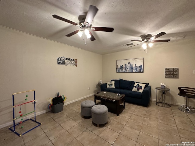 living room featuring ceiling fan, tile patterned flooring, and a textured ceiling