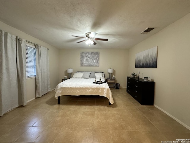 tiled bedroom with a textured ceiling and ceiling fan