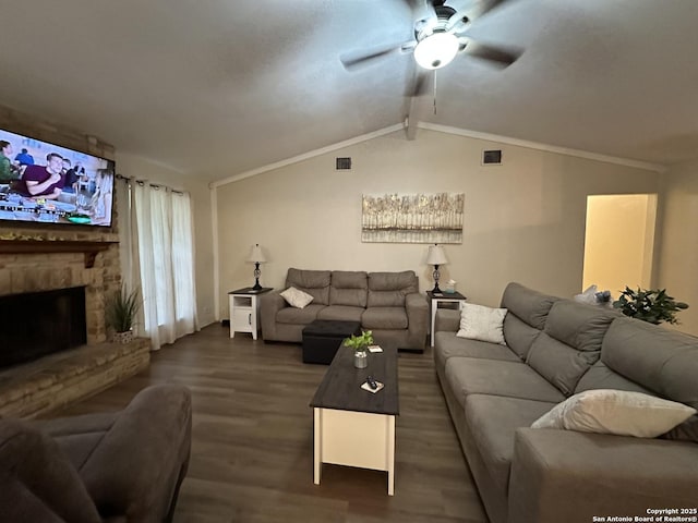 living room featuring lofted ceiling, a stone fireplace, ornamental molding, and dark hardwood / wood-style floors