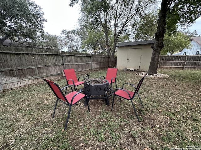 view of yard featuring a storage shed and an outdoor fire pit