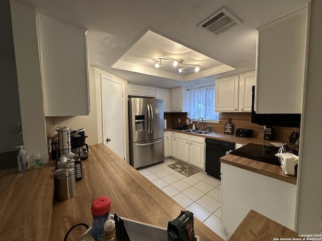 kitchen with stainless steel refrigerator with ice dispenser, sink, a tray ceiling, dishwasher, and white cabinets